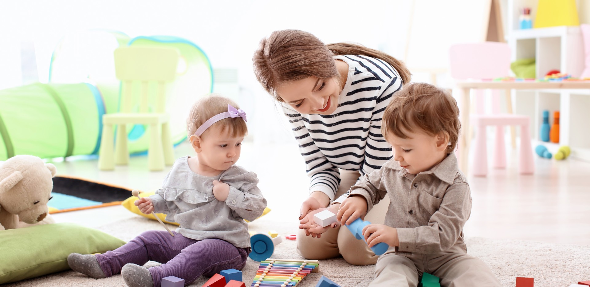 Accompagnatrice petite enfance en train de s'occuper de deux enfants