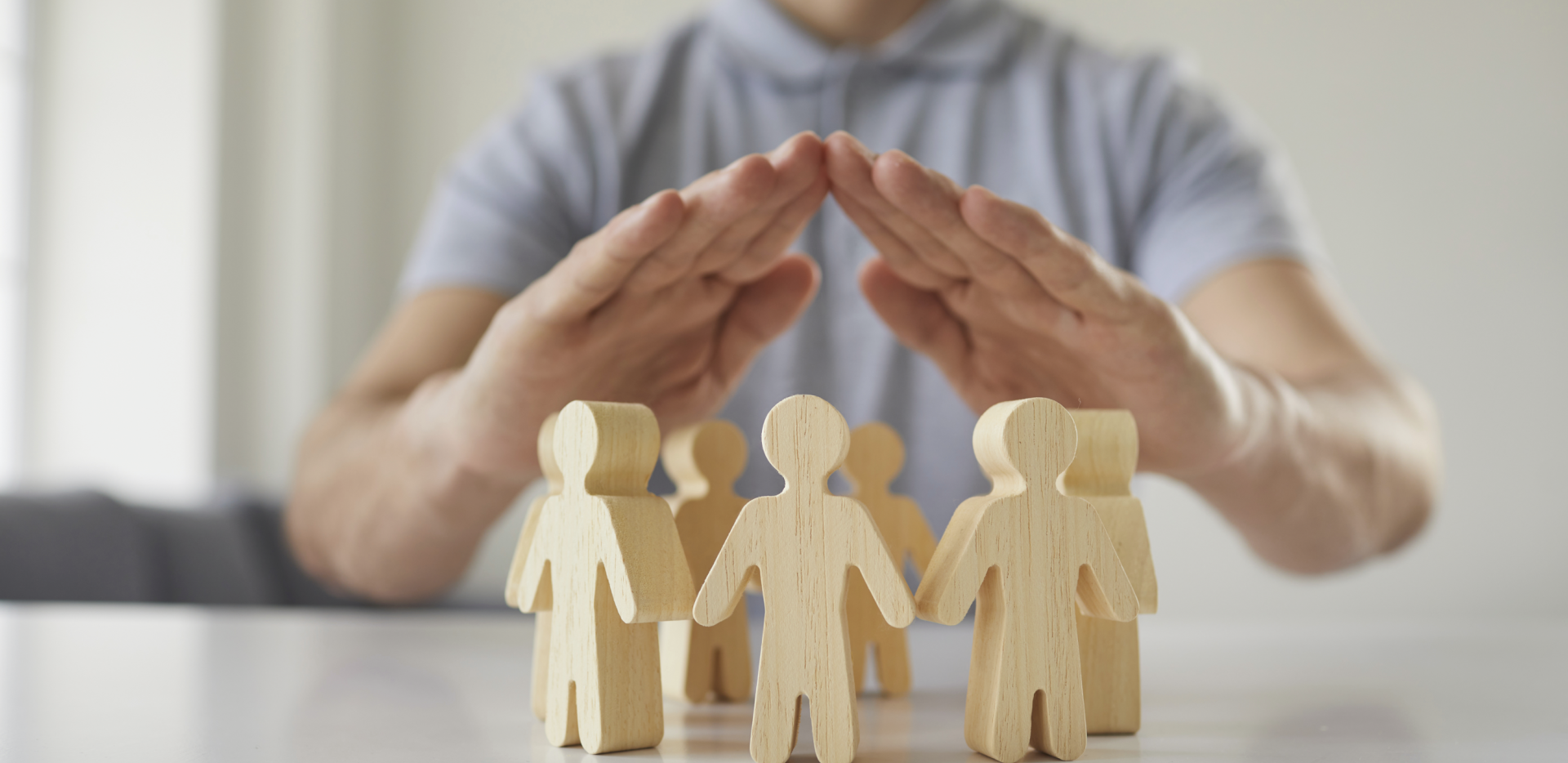 Homme mettant ses mains au dessus de bonhommes en bois en rond