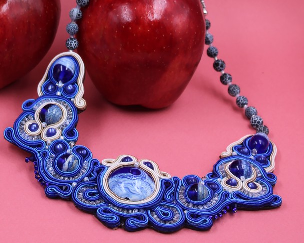 Photo d'un collier bleu sur une pomme rouge