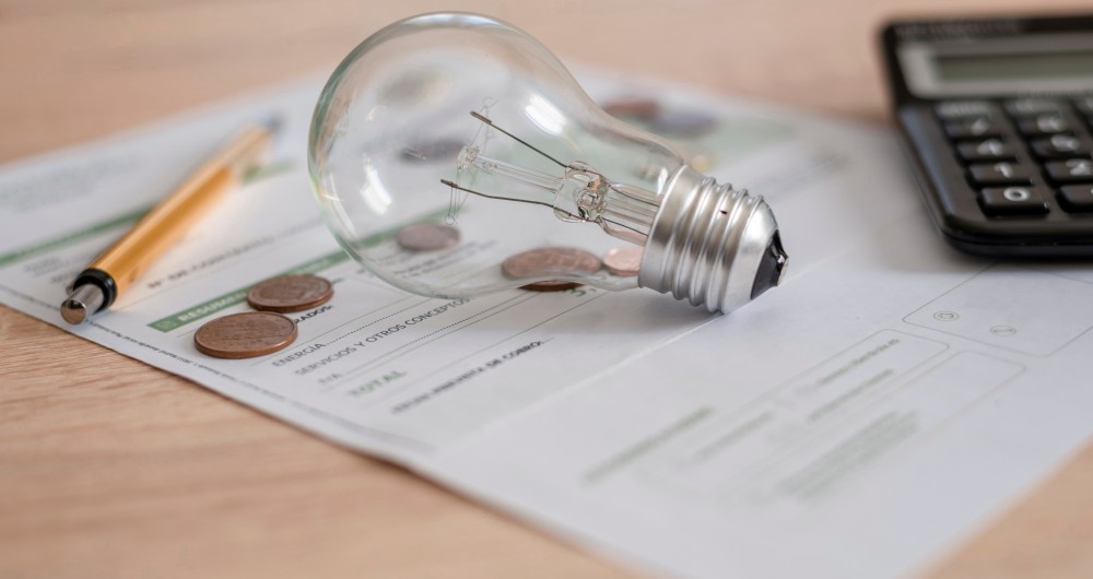 Ampoule posé sur une facture et une calculatrice est à côté