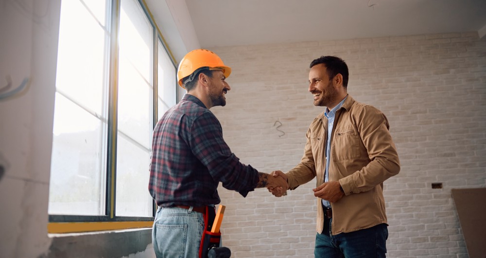 Artisan du bâtiment qui serra la main à une autre personne