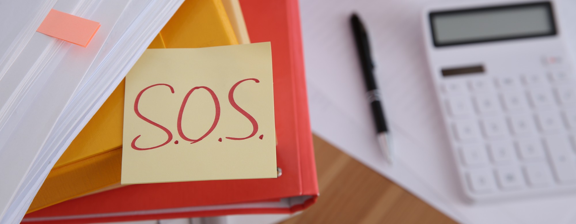 Bureau rempli avec un post-it SOS