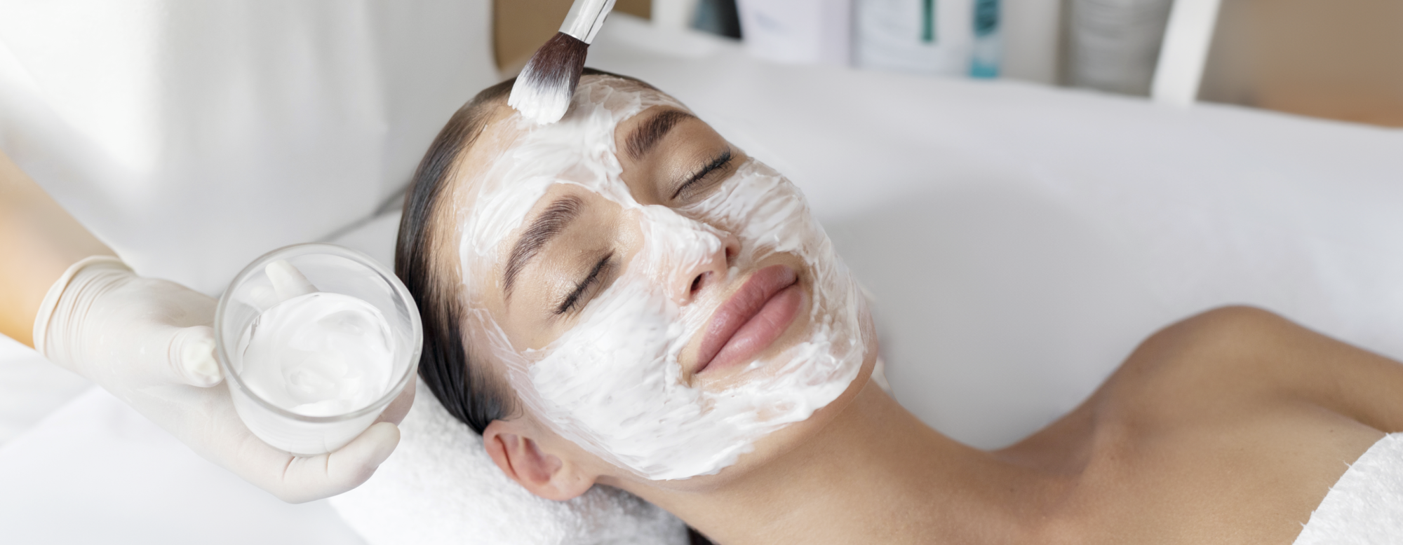 Cosméticienne applique un masque beauté sur une cliente