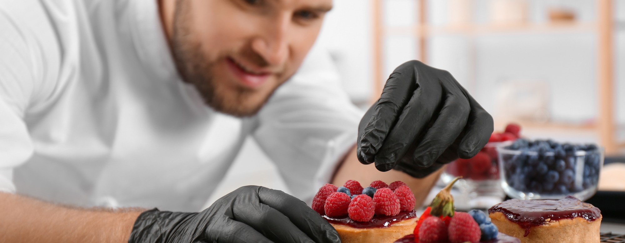 Pâtissier prépare des tartelettes framboise