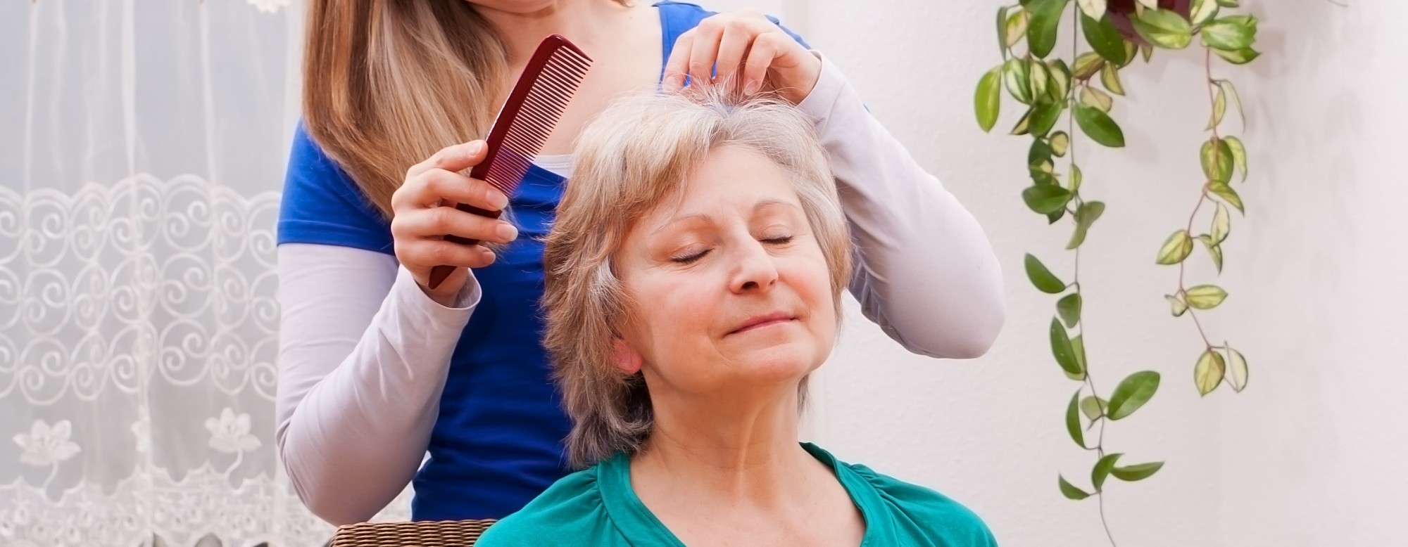 Socio coiffeuse coiffe une personne âgée