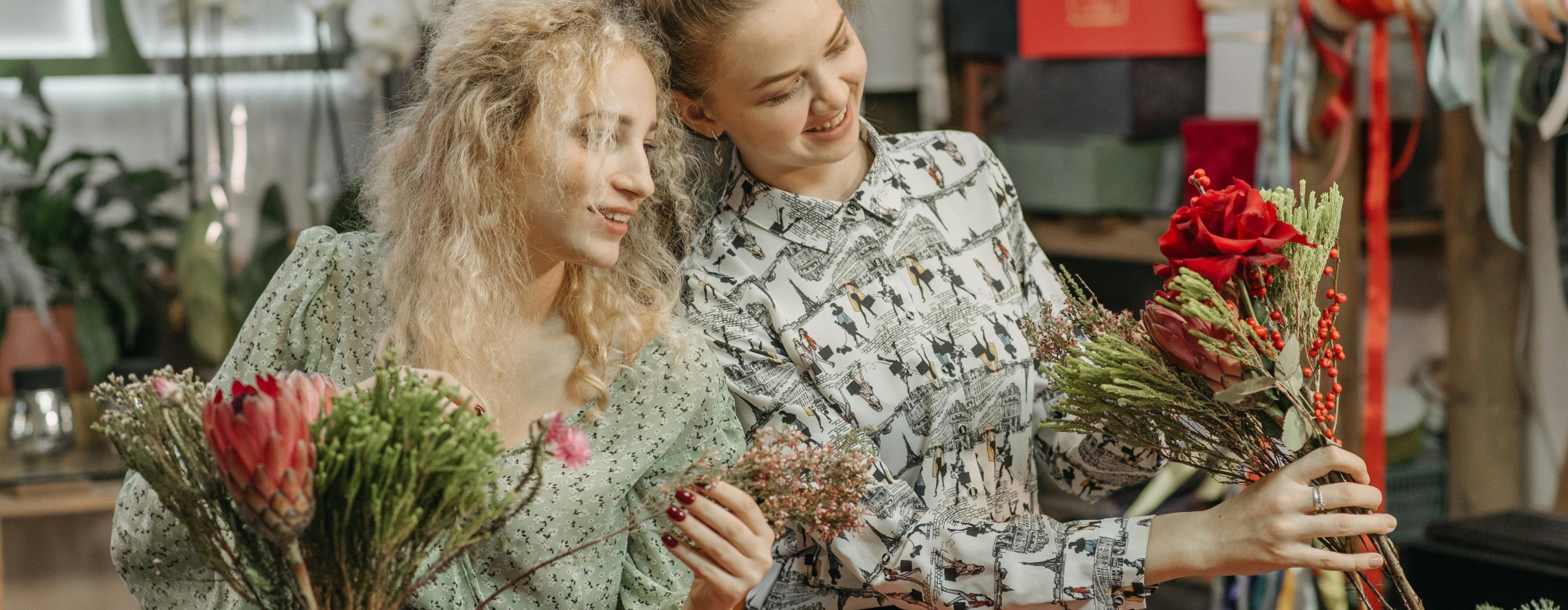 Deux fleuristes travaillant ensemble sur une composition florale dans un atelier de fleuristerie