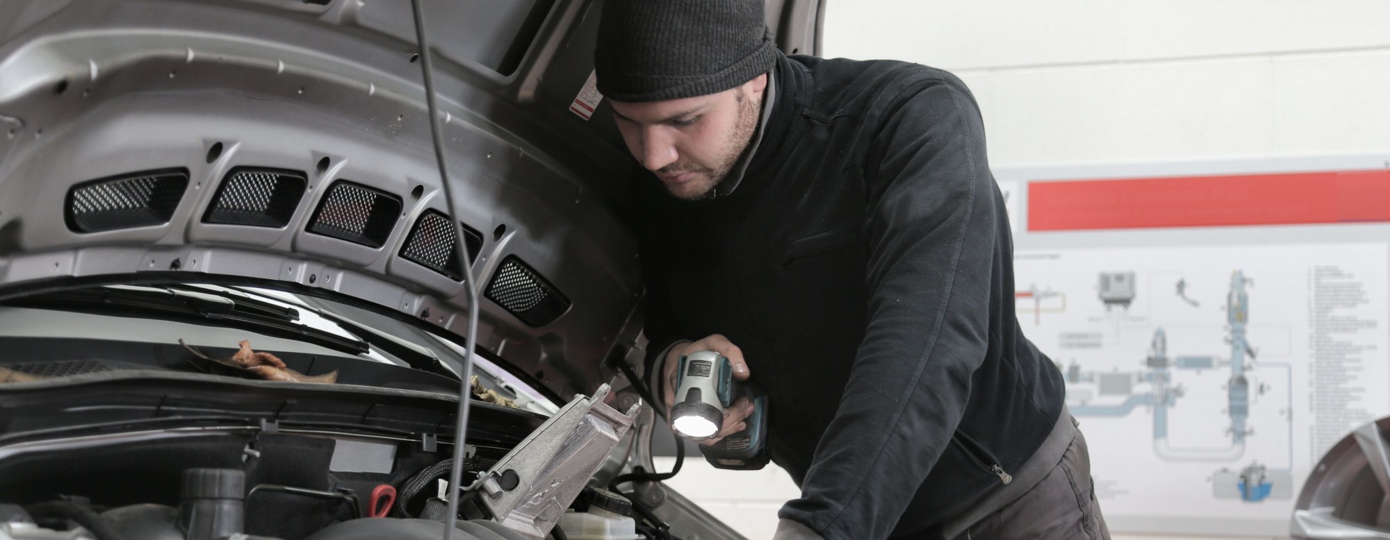 Technicien en formation CAP maintenance véhicules légers travaillant sous le capot d'une voiture