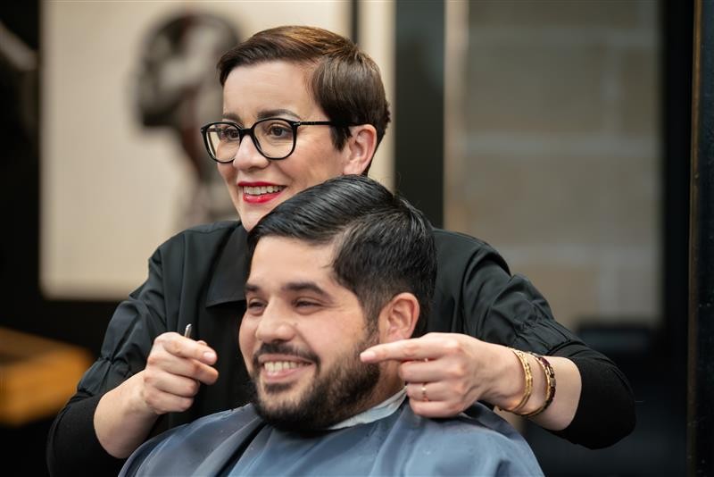 Femme barbière avec un client content