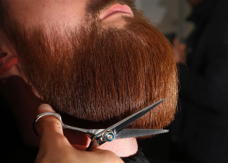 Barber fait la taille sur une barbe rousse