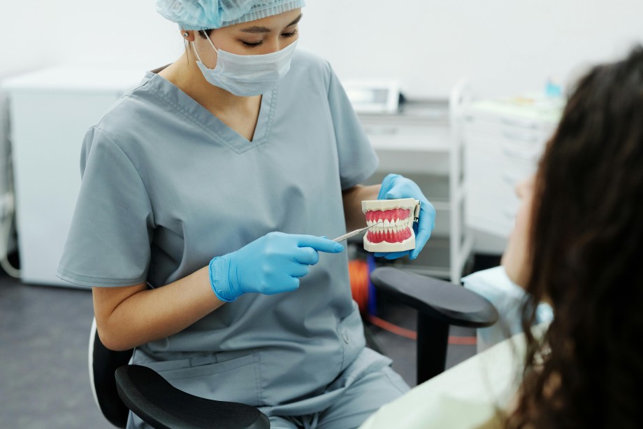 Professionnelle de santé dentaire expliquant une prothèse dentaire à une patiente dans un cabinet dentaire
