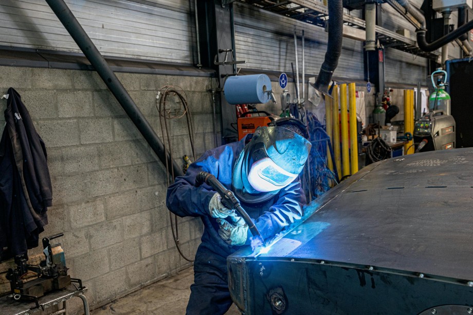 Soudeur à l'arc en atelier industriel avec équipements de protection.