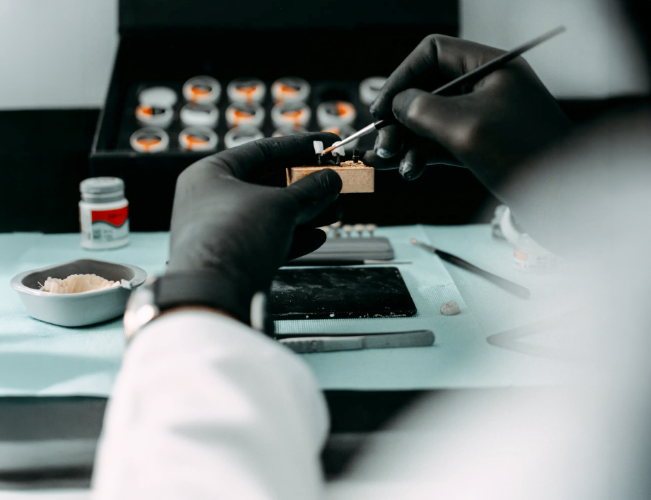 Prothésiste dentaire travaillant avec précision sur une prothèse dentaire dans un laboratoire