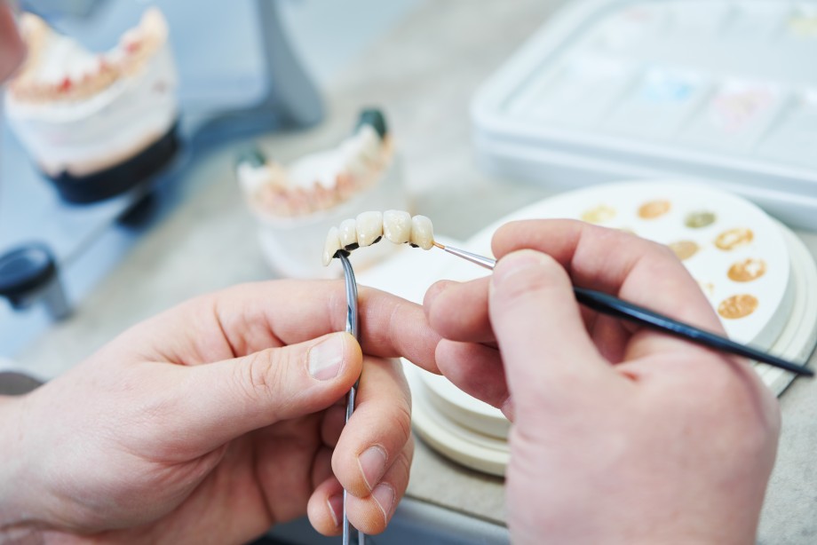 mains d'un prothésiste dentaire en plein travail