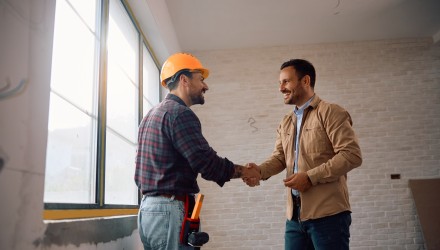 Artisan du bâtiment qui serra la main à une autre personne