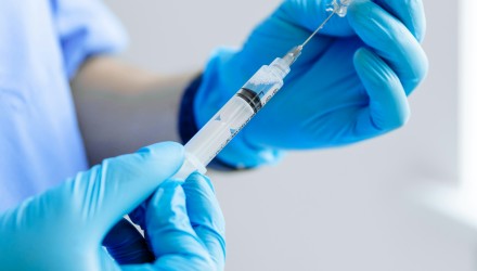 Personnel médical équipé de gants de protection préparant une injection