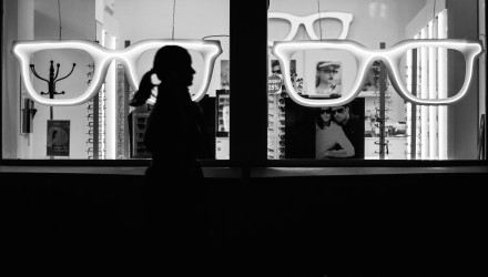 Une femme marchant devant une boutique d'optique 