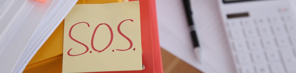 Bureau rempli avec un post-it SOS