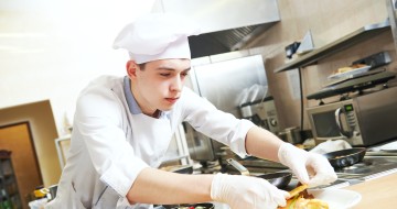 commis de cuisine qui dresse des assiettes