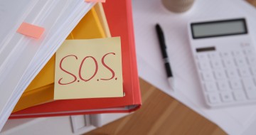 Bureau rempli avec un post-it SOS