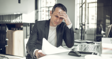 Homme en galère face à un document administratif