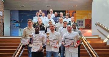 une photo de groupe des gagnants dans des escaliers tenant leurs diplômes et trophées