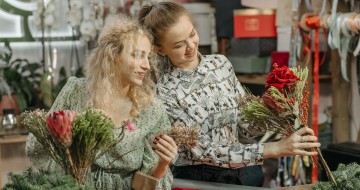 Deux fleuristes travaillant ensemble sur une composition florale dans un atelier de fleuristerie