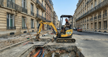 Artisan utilisant un tractopelle en pleine rue