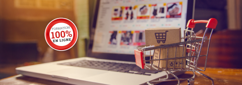 Boîtes en carton avec un logo de panier d’achat dans un chariot sur un clavier d’ordinateur portable.