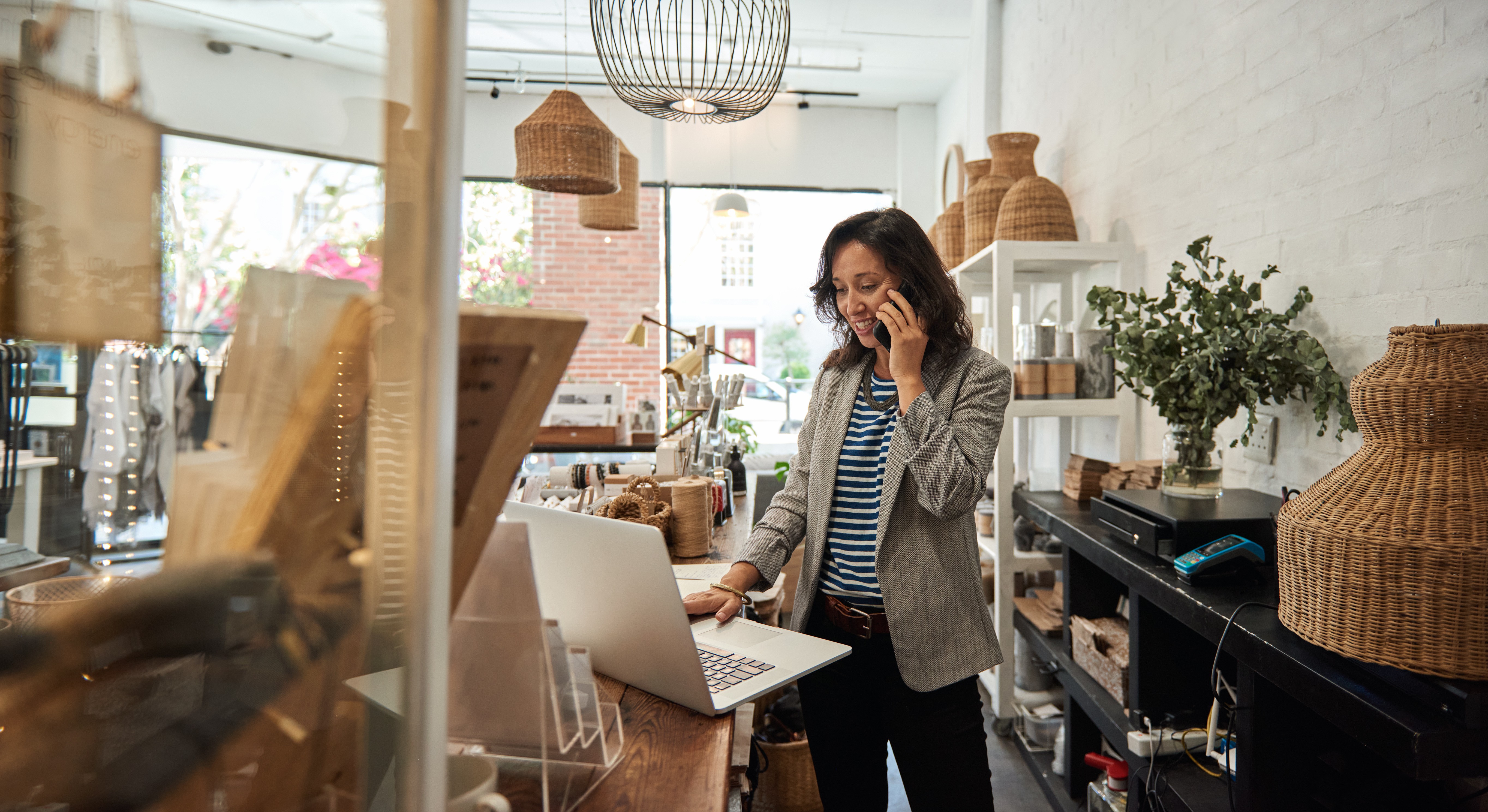 Femme asiatique souriante au téléphone portable dans son magasin